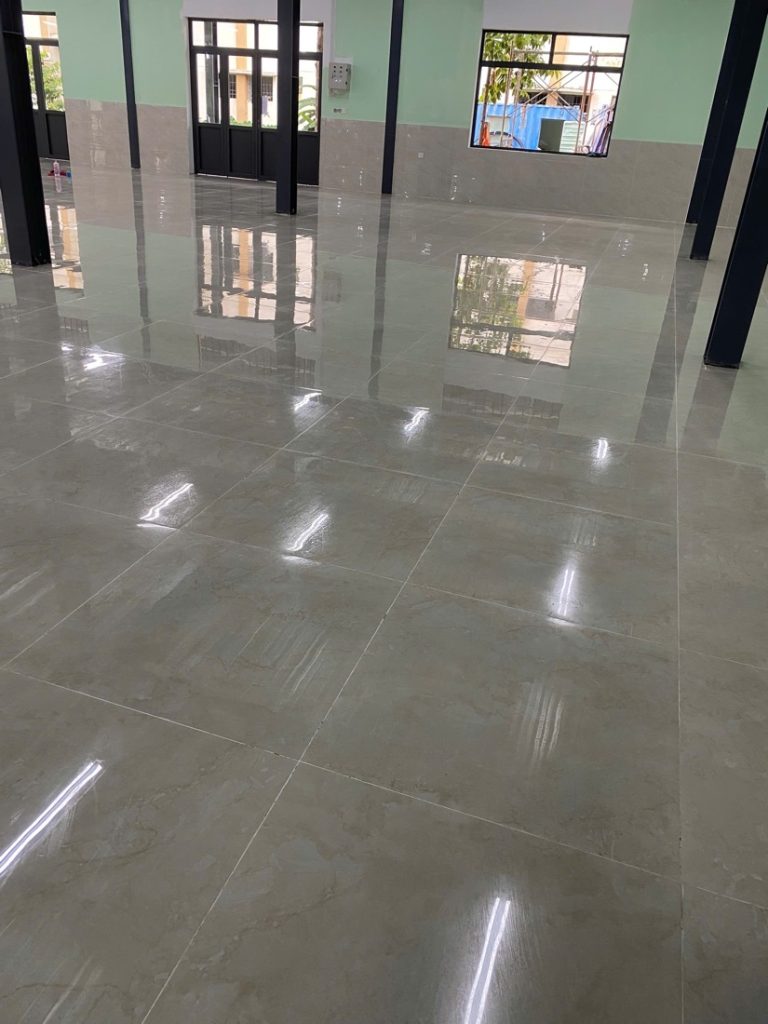 Sàn gạch nhà xưởng sau khi Cánh Diều chà và đánh bóng, bề mặt phản chiếu rõ